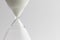 Close up of hourglass with white sand and copy space on white background