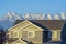 Close up of house exterior with snow capped mountain and blue sky background