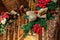 Close-up house wooden staricase handrails railings decorated with artificial holly poinsettia flower, burlap bow