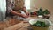 Close-up housewife peeling garlic, standing at kitchen table with ingredients for pickle, for marinating fresh cucumbers