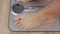 Close up human foot stepping on weighing scale for weight control