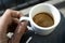 Close up of Human hand with small white empty cup espresso coffee in bright sunlight. Meditation moment. Coffee brake.