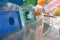 Close up of human hand throwing used paper into recycling bin a