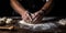 Close-up of human hands in the apron knead the dough on a black wooden table , concept of Tactile sensation, created