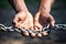 Close-up of human hands holding a metal chain, symbolizing connection, strength, and the potential for freedom