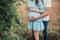 Close up of human hands holding pregnant belly, closeup happy family awaiting baby, standing on green grass, body part, young fami