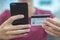 Close-up human hands with mobile phone and credit card. Person holds smartphone and bank card, closeup shot. On foreground male