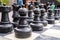 Close up of human sized black chess pieces with pawns in front