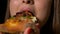 Close-up of hungry female mouth licking lips and eating a slice of freshly baked pizza