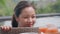 Close-up of a hungry girl looking with interest at a basket with a floating breakfast. A young beautiful Asian girl