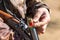 Close up of hunter loading shotgun, holds a gun and ammunition