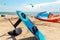 Close-up hydrofoil surf board and kite equipment on sand beach shore watersport spot on bright sunny day against sea