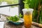 Close up of ice cold Longan fruit juice in glass with straw on old table