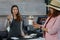 Close up iced beverage in customer hands and blurred background the waitress thumb up at counter bar in the coffee shop