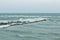 Close-up of the icy seashore, frozen waves, rocks and sun glare on the ice