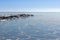 Close-up of the icy seashore, frozen waves, rocks and sun glare on the ice