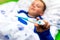 Close up ill young child or schoolboy, lying in bed shows a electronic thermometer, height of his fever