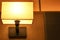 close up of Illuminated lamp in dimly lit bedroom at night in a luxury hotel.