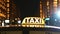 Close up of illuminated taxi sign on roof car in night city