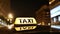 Close up of illuminated taxi sign on roof car in night city
