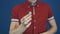 Close up illusionist in red shirt perform magic trick disappear in hands coin