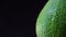 Close-up illustration of left part of green avocado spining counterclockwise on black background.