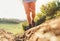 Close up image backpacker traveler feet in trekking boots on mountain dirty path at summertime sunny day