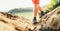 Close up image backpacker traveler feet in trekking boots on mountain dirty path at summertime sunny day