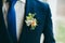 Close up image of beautiful boutonniere on the groom`s jacket. Soft focus on boutonniere. Artwork