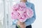 Close up image of boy in blue shirt hold big gentle bouquet of pink peony. Congratulations with birthday, mother`s day, anniversar