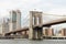 Close up image of the Brooklyn Bridge from the East River with Manhattan in the background.