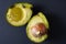 Close up image of a bruised and imperfect avocado on a black background- use these and avoid food waste