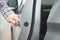 Close up image of a businessman hand on handle opening a car door.