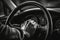 A close-up image of a driver\\\'s hand firmly gripping the steering wheel as their car overtakes, with a blurred background,