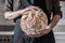 Close-up image of female hands holding big loaf of white bread.