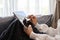 Close-up image, A female relaxes in the living room, sits on sofa and uses a digital tablet