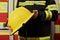 Close up image of a firefighters helmet. Firefighter holding a yellow helmet