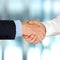 Close-up image of a firm handshake between two colleagues in of