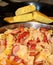 Close-up image of fried cabbage, sausage, onions, and tomatoes with portions of cornbread in background