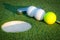 Close up image of golf hole with balls and putt