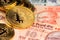 Close up image of gplden Bitcoin with Indian Rupee banknotes. Bitcoin on India Rupee Cryptocurrency against money from India