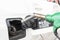 Close up image of green gas pump near hole of car tank ready for refueling car
