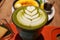 Close up image of Green matcha latte with latte art on a glass with Vanilla CrÃ¨me BrÃ»lÃ©e dessert