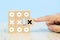 Close-up image of hand-picked cube shaped wooden toy blocks with X symbol stacked for business management and strategy