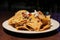 Close up image of loaded Nachos with sour cream on a wooden table