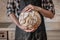 Close-up image of male hands holding big loaf of white bread. Pe