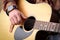 Close up image of man strumming guitar