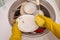 Close-up image of man Washing stack of dishes.