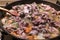 Close up image of meat with vegetables stewing in the pan with wooden spoon. Above view,