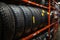 Close-up image of new tires arranged on metal shelving in a warehouse, highlighting the tread patterns and brand labels,